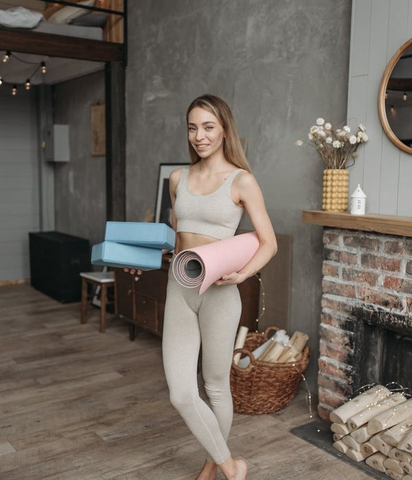 Woman in activewear smiling and feeling energetic in a modern, calm space.